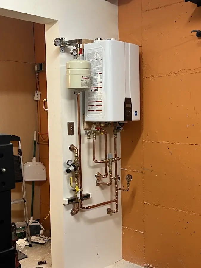 Plumbing technician inspecting water heater connections in Sienna